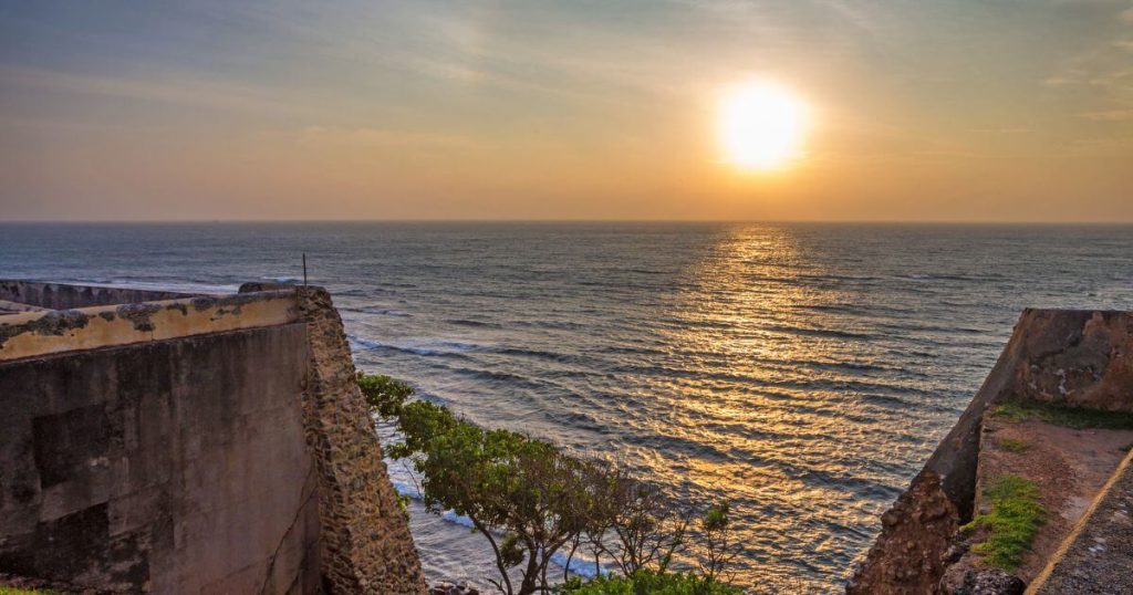  加勒堡的古老石牆延伸至海邊，夕陽西下，海面映照出金色的光芒。這幅壯麗的日落景象，完美地展現了斯里蘭卡加勒堡歷史與自然的和諧共存。