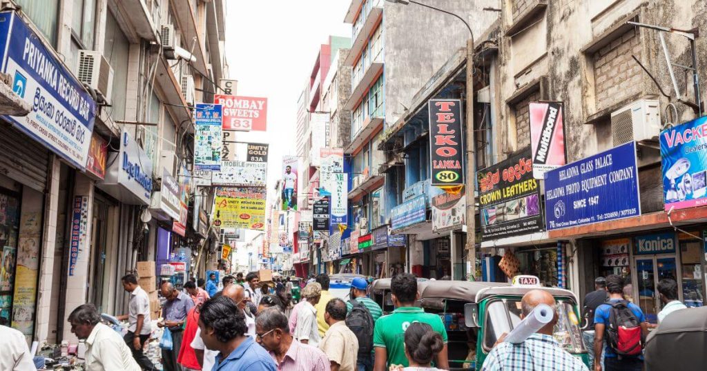 圖片中展示了斯里蘭卡科倫坡Pettah Market的繁忙街景,擠滿了購物者與商店招牌,充滿活力的市場氛圍讓這裡成為當地著名的購物熱點。