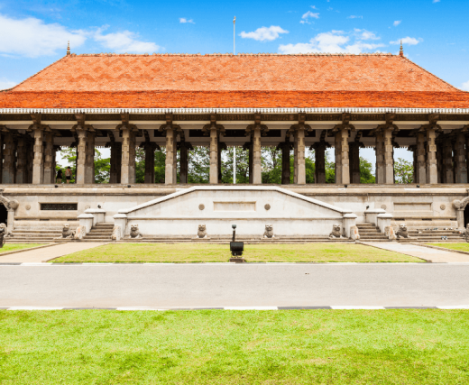 這張圖片展示了斯里蘭卡獨立廣場的壯麗建築，該廣場是該國重要的歷史地標，象徵著斯里蘭卡從英國統治下獲得獨立。廣場的建築風格融合了傳統與現代元素，周圍環繞著綠意盎然的草坪，是當地人民慶祝和紀念獨立的重要場所。